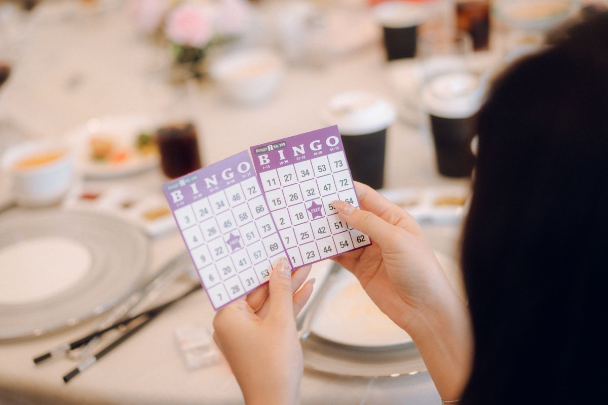 Wedding guest holding bingo cards during a banquet game