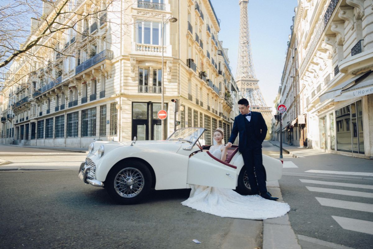 Couple posed with a vintage car on a Paris street during their pre-wedding photoshoot