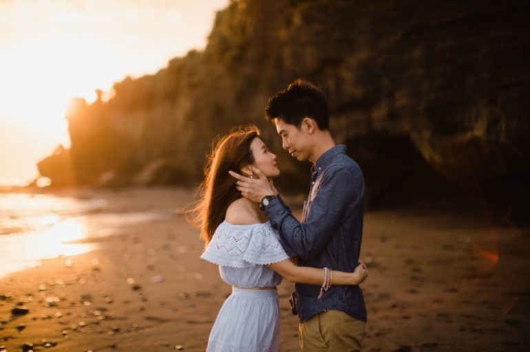 Romantic couple posing at stone beach Stock Photo by ©AnnHaritonenko  75375857