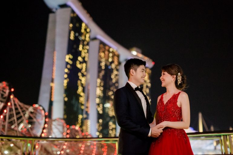 bride in red gown with singapore night cityscape