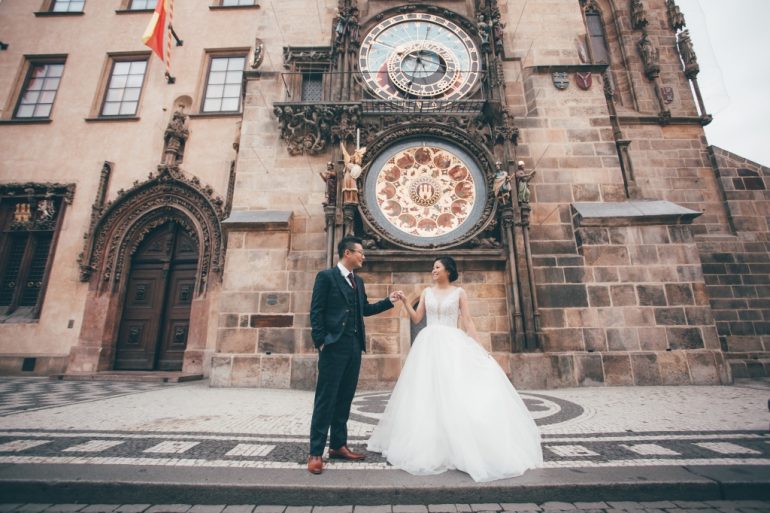 bride in white princess gown by astronomical tower in prague
