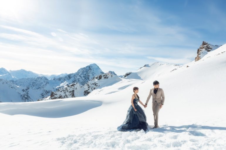 bride in ruffled blue dress on snow mountain
