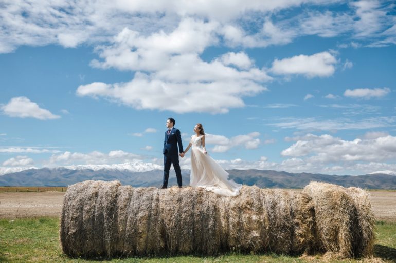 wedding photography new zealand couple on rolled haystacks