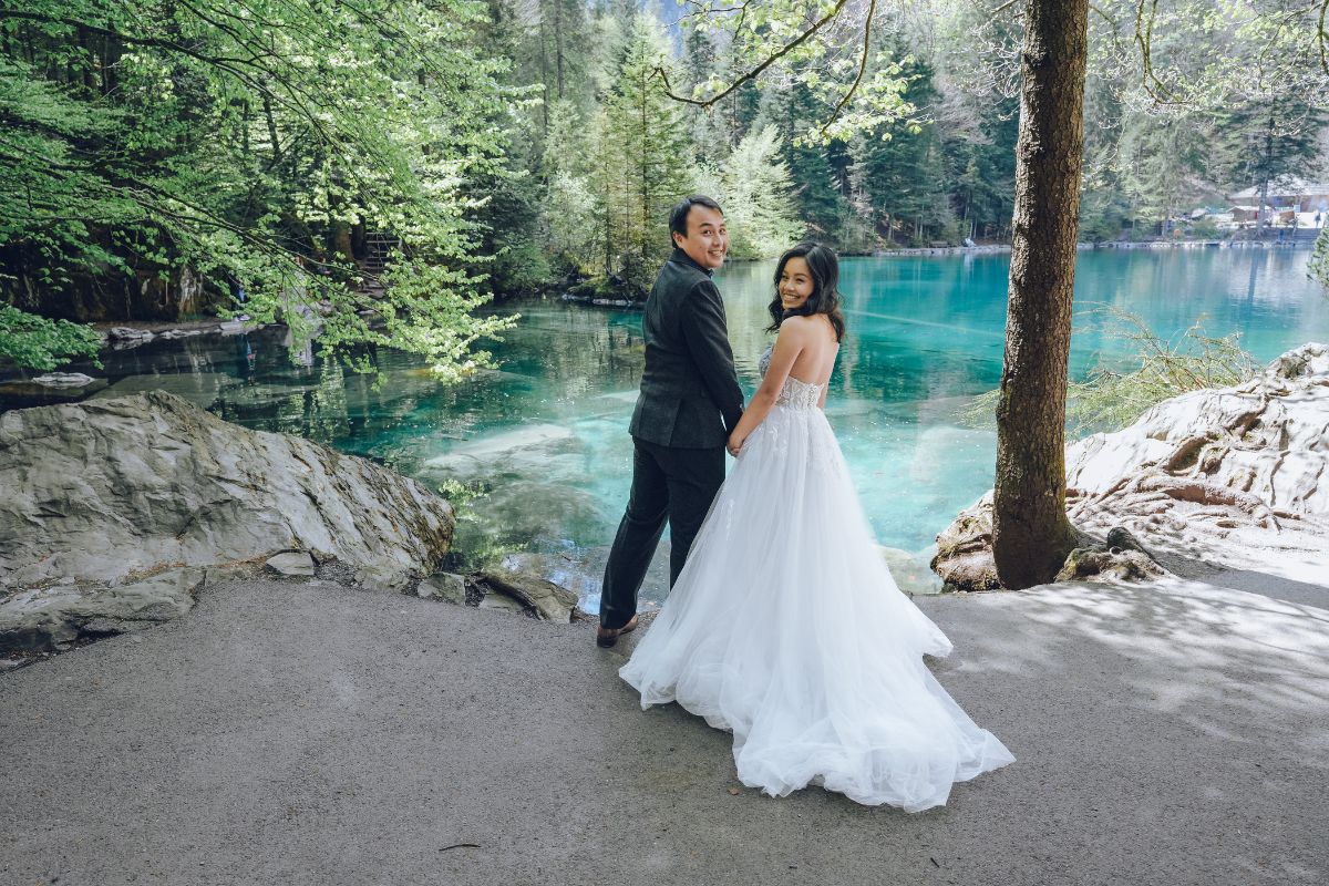 Couple having a pre-wedding photoshoot at Lake Blausee with turquoise waters and forest backdrop in Switzerland