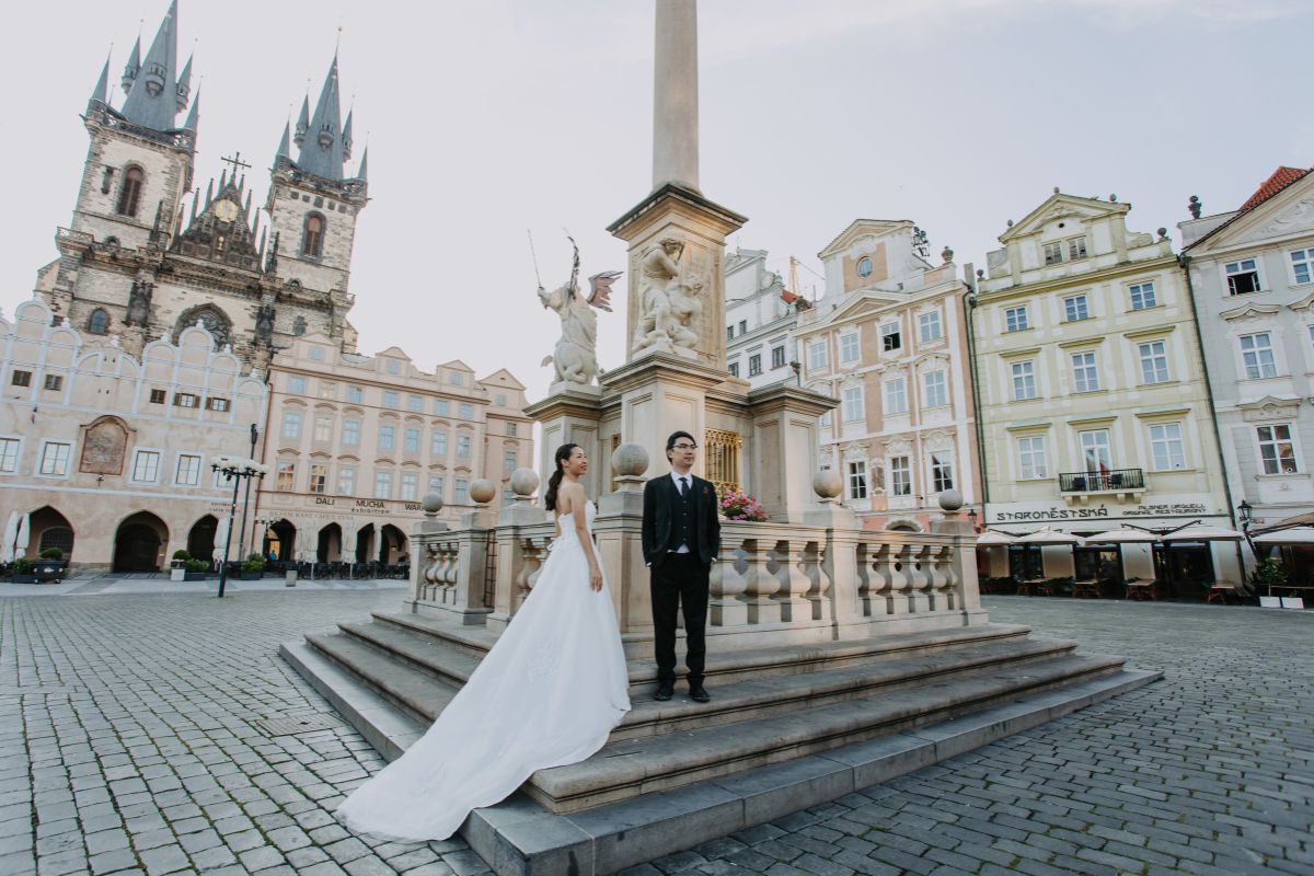 Couple posing in Prague’s Old Town Square during their pre-wedding photoshoot
