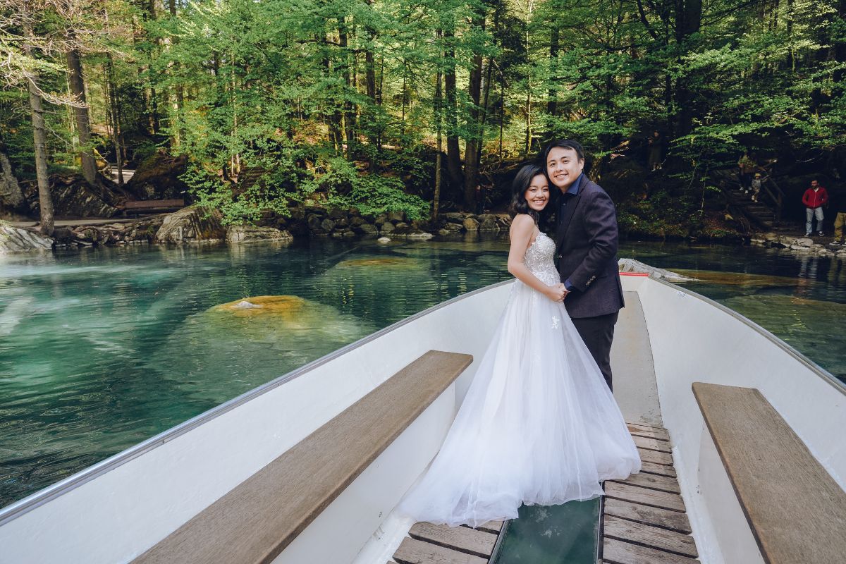 "Couple on a wooden boat gliding across the turquoise waters of Lake Blausee during a pre-wedding shoot.