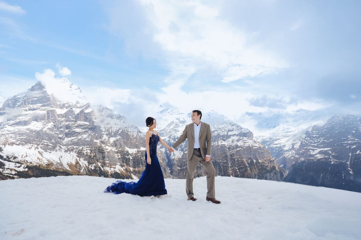 Couple having a pre-wedding photoshoot at First Cliff Walk in Grindelwald, surrounded by snow and alpine peaks