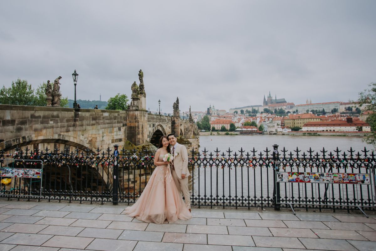 Couple posing during pre-wedding photoshoot with historic Prague architecture in the background