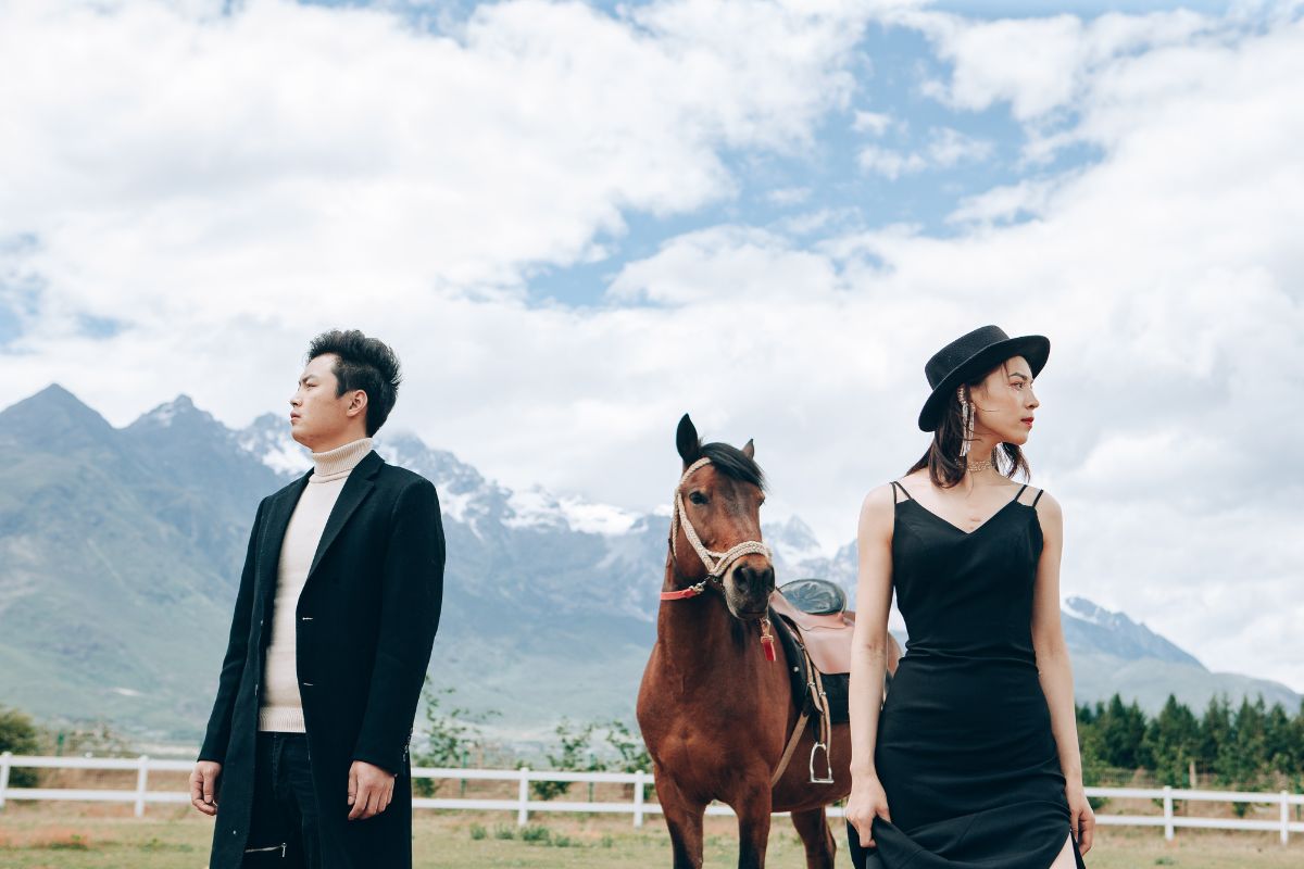 Couple having a pre-wedding photoshoot with a horse in the scenic fields of Yunnan