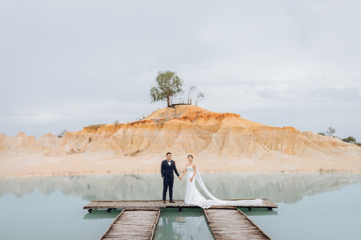 Couple posing for a pre-wedding shoot at the scenic Blue Lake dunes in Bintan