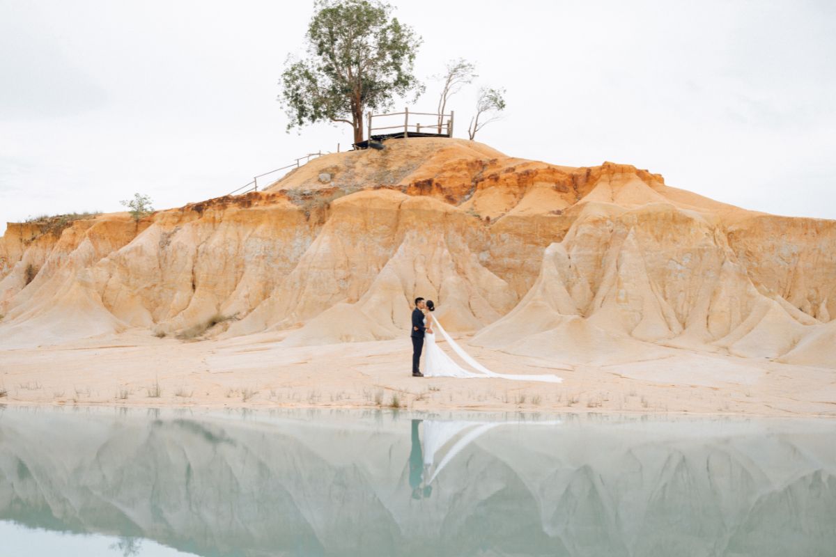 Couple posing for a pre-wedding shoot at the scenic Blue Lake dunes in Bintan