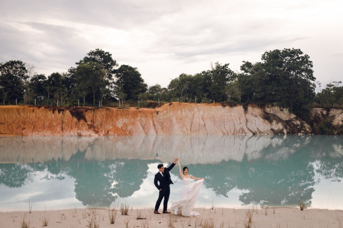 Couple posing for a pre-wedding shoot at the scenic Kijang Blue Lake in Bintan