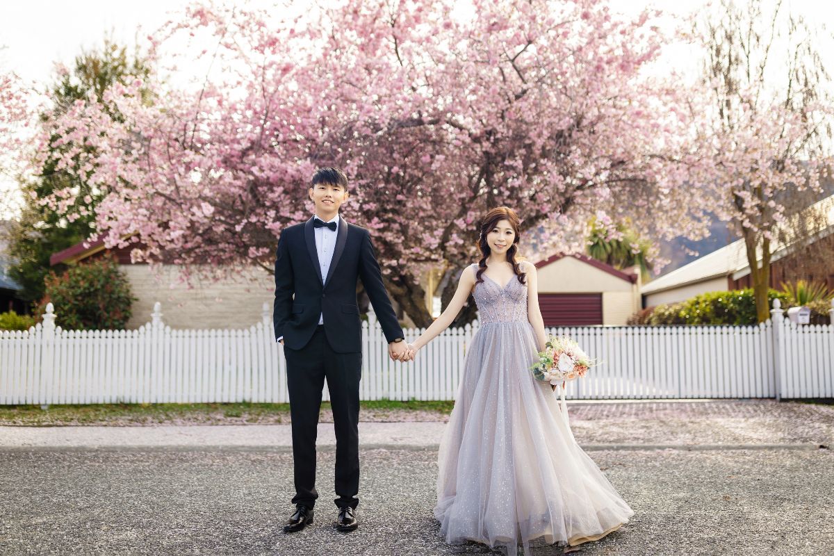 Couple having a romantic pre-wedding photoshoot during cherry blossom season in New Zealand